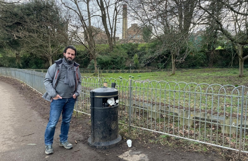 Hove Park Ward Councillor Samer Bagaeen next to an overflowing bin in Hove Park, a public space which would benefit from new bins with greater capacity under the Conservatives’ City Budget amendments.