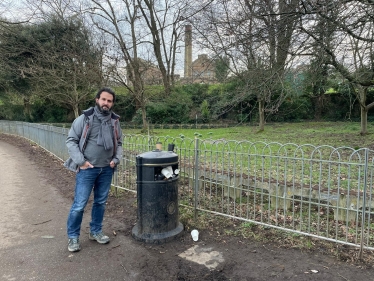 Hove Park Ward Councillor Samer Bagaeen next to an overflowing bin in Hove Park, a public space which would benefit from new bins with greater capacity under the Conservatives’ City Budget amendments.